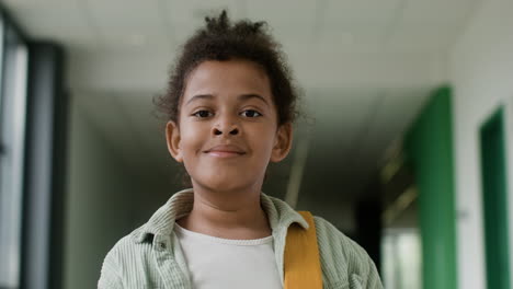 schoolgirl looking at camera in school corridor.