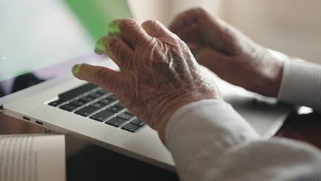 wrinkled man hands typing on trendy laptop keyboard, senior man working on modern laptop typing on keyboard. elderly man in retirement working at home, retired teacher thing project on computer