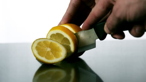 man slicing lemon with large knife
