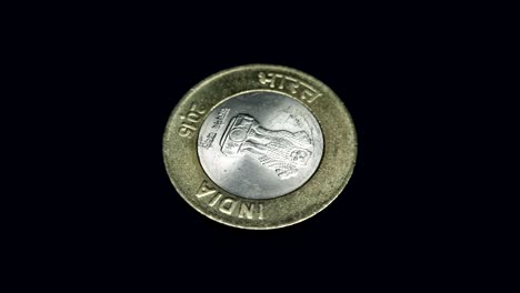 la moneda india de 10 rupias de lanzamiento de 2015 gira sobre un fondo negro. macro. primer plano