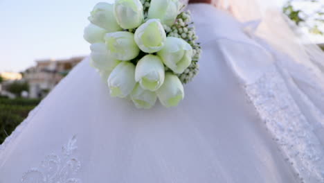 bride and groom with a bouquet in the garden - camera moving up - low angle