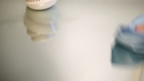 a man cleaning a glass mirror table with