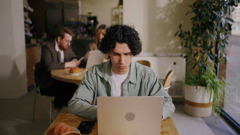 man working on his laptop at a cafe