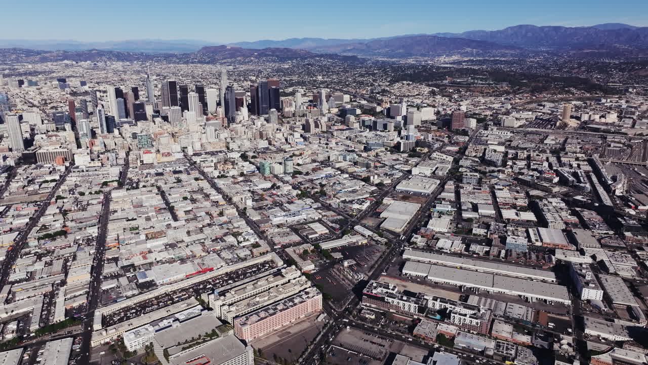 Aerial View of a Bustling City with Skyscrapers and Mountains in the Background