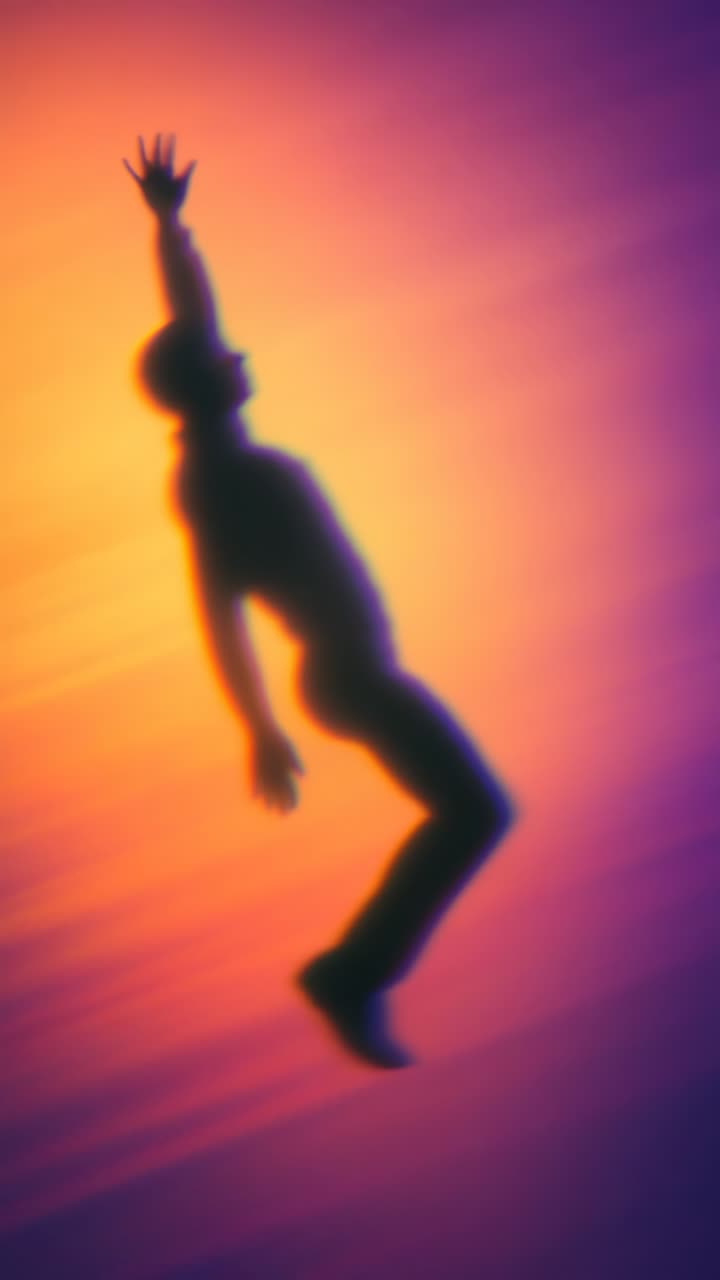 Silhouette di una persona che cade con colori sfumati vivaci, ripresa da un'angolazione dal basso
