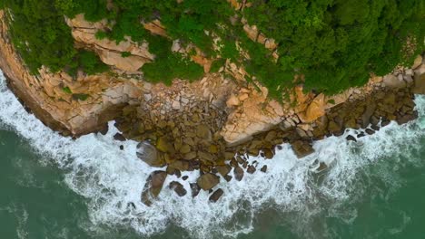 Slow-motion-footage-of-the-sea-and-a-cliff-with-some-pelicans-crossing-the-scene