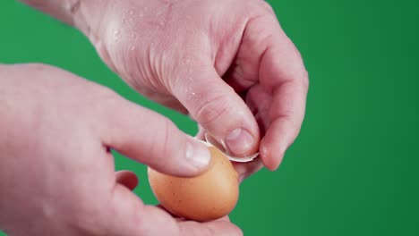 men's hands clean a boiled egg from the shell.