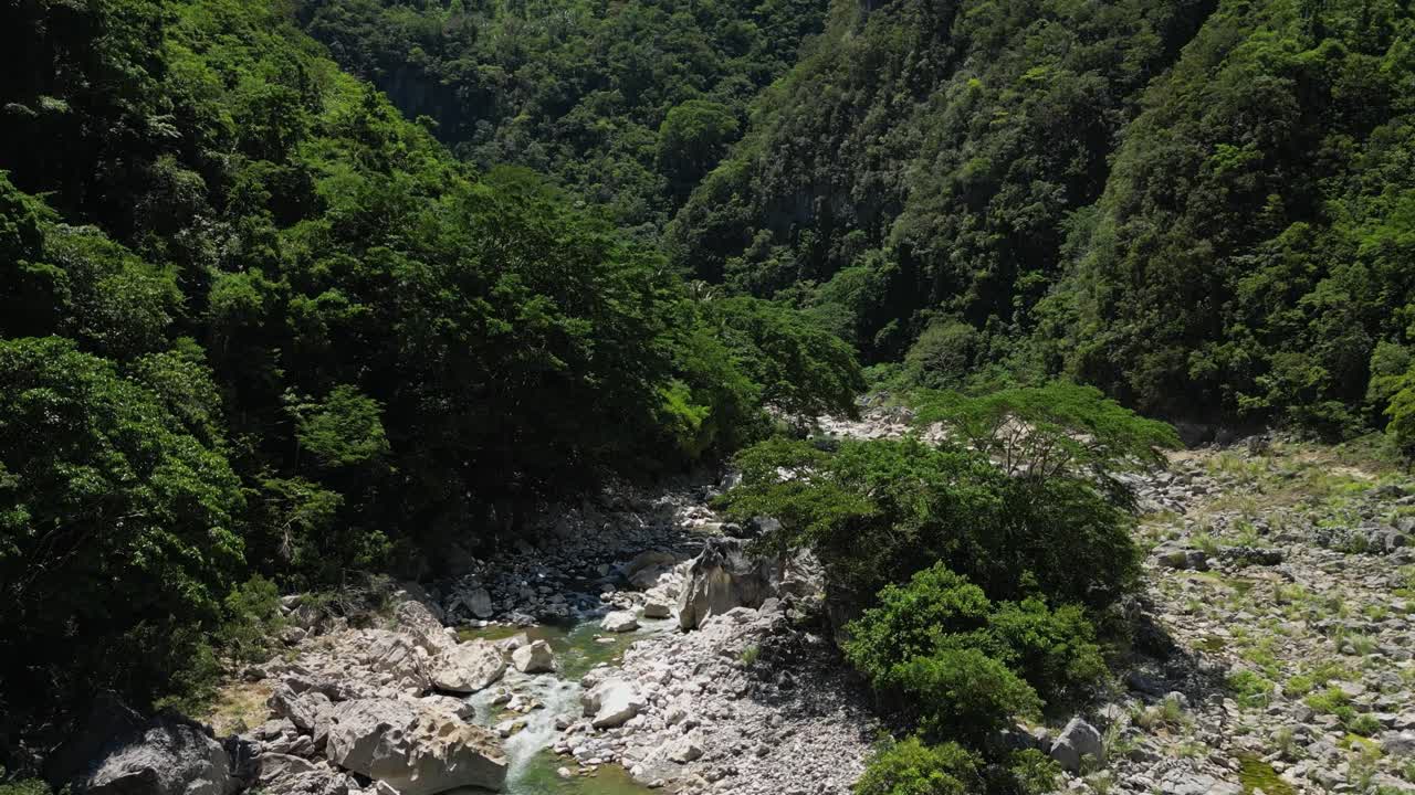A calm drone shot moves forward over Tinipak River, gradually tilting up to reveal the vast landscape, with a subtle view of the river remaining visible throughout the shot