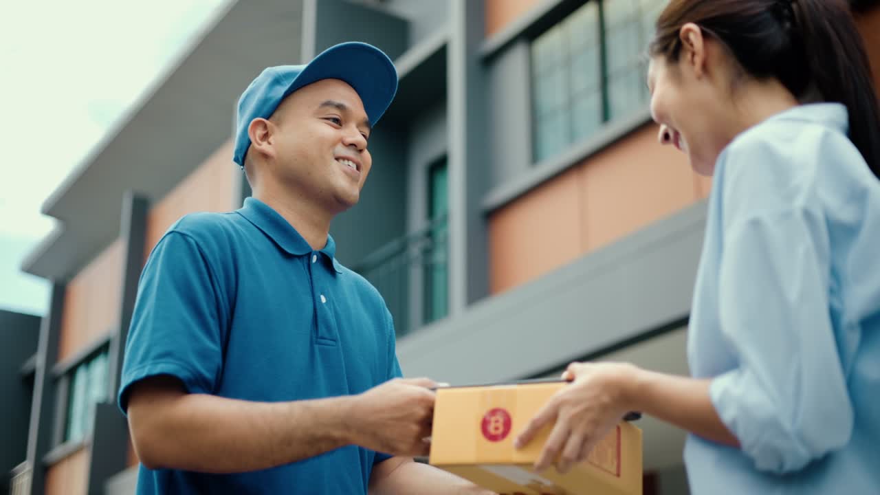 mujer joven firmando firma electrónica en una tableta para el acuerdo de contrato digital recibiendo paquete de un repartidor azul de compras en línea. mensajero hombre entregando paquete al destino.