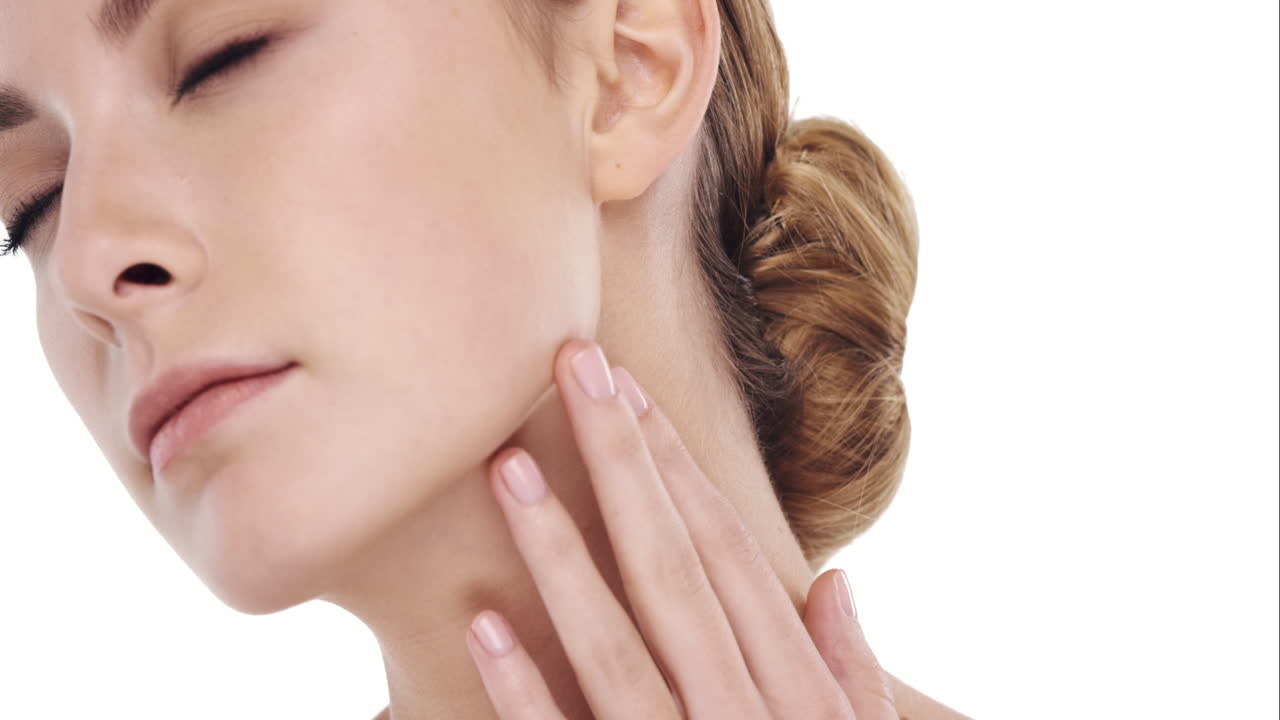 Ritratto di bellezza di una donna che si tocca il viso in slow motion, concetto di cura della pelle su sfondo bianco.