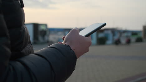 persona que utiliza un teléfono inteligente al aire libre