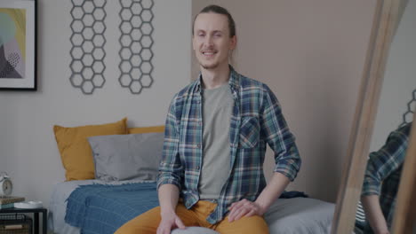 man sitting comfortably in a bedroom