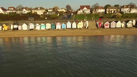 row of colorful beach huts on a sandy shore