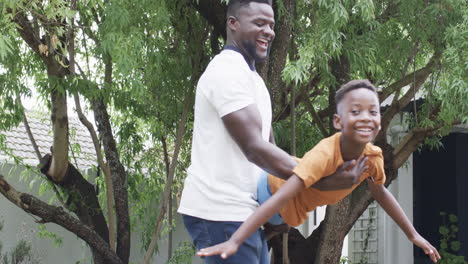 african american father plays with son outdoors