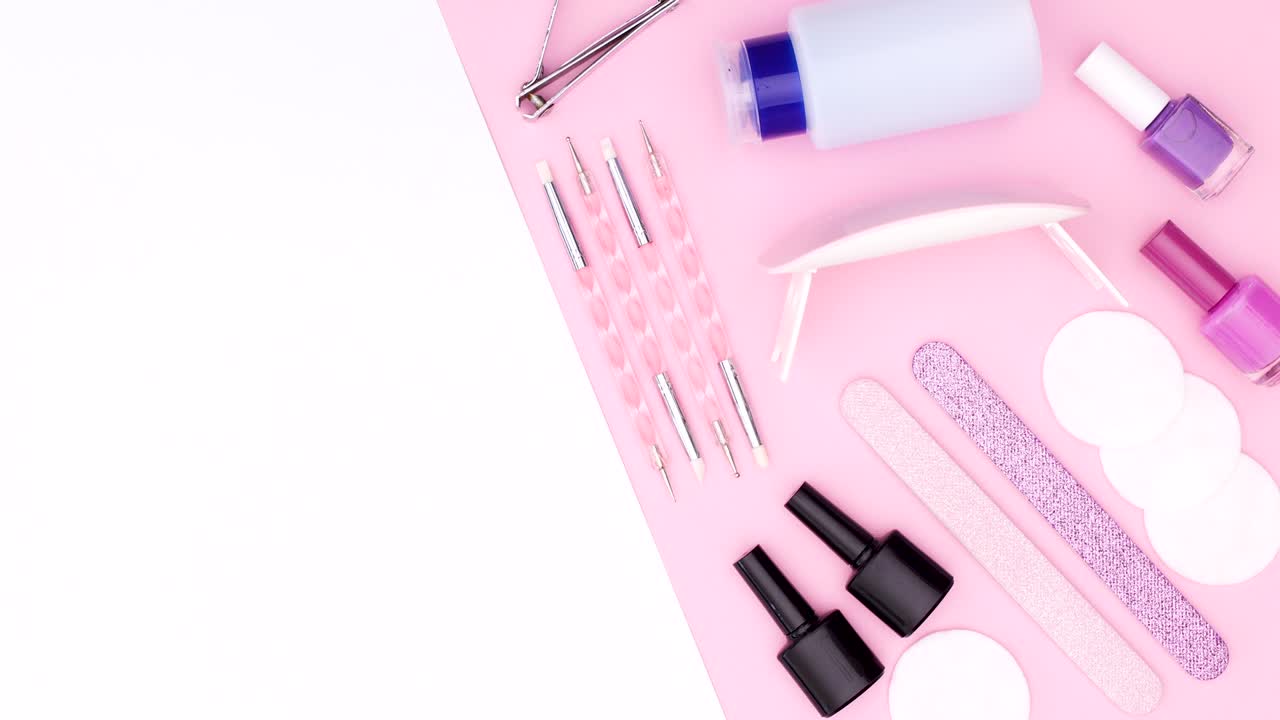 Manicure tools and nail polish bottles move on pink white theme. Stop motion