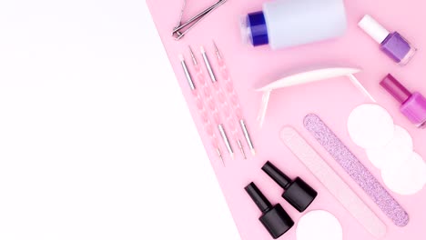 manicure tools and nail polish bottles move on pink white theme. stop motion