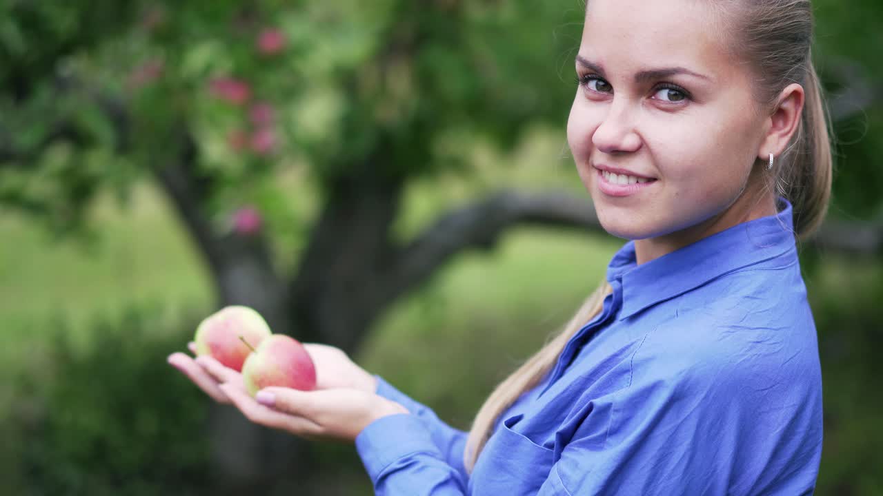 A young girl holds ripe red apples in her hands. Organic food