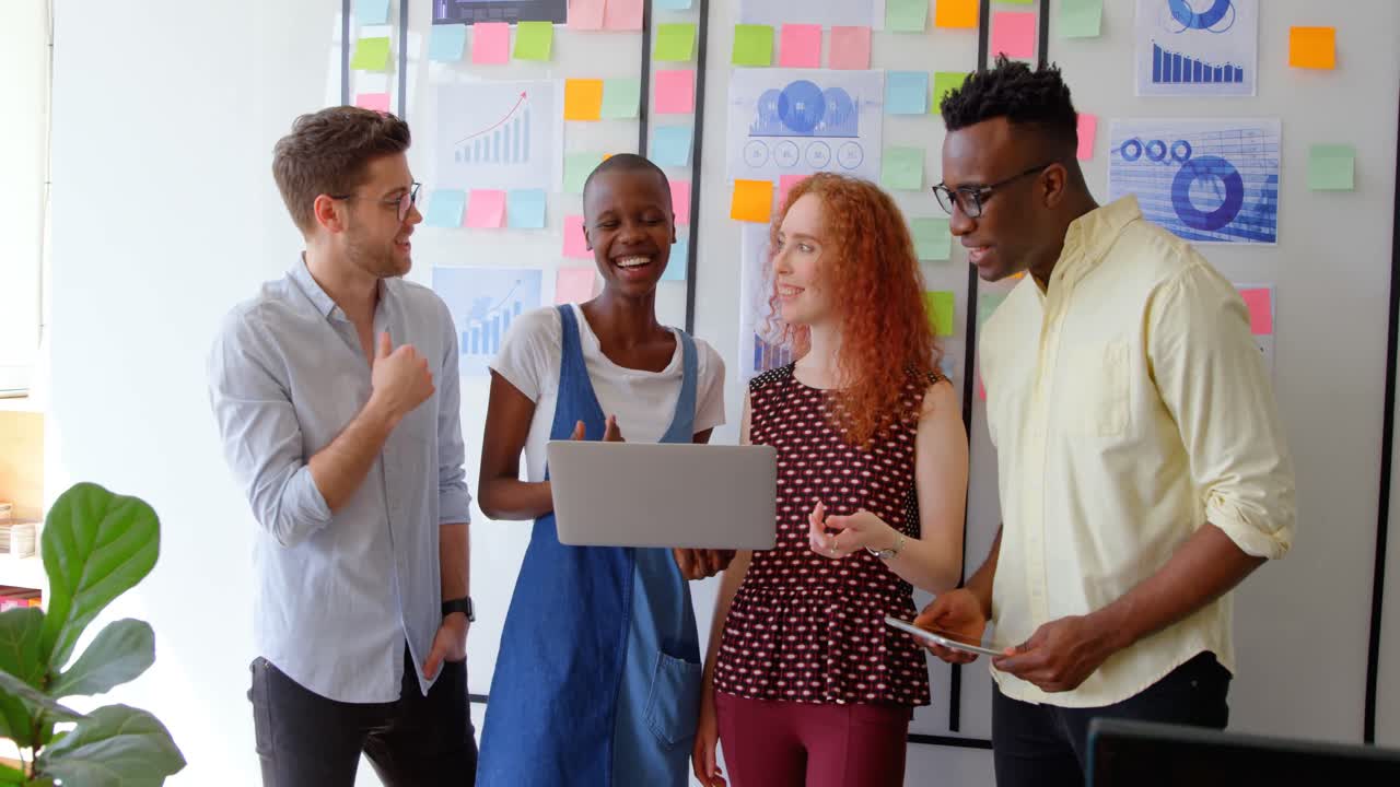 Front view of young mixed-race business team working on laptop in a modern office 4k