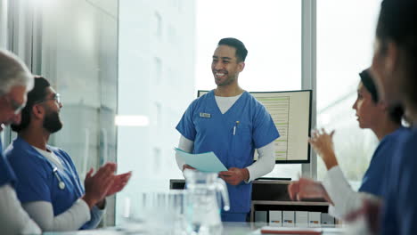 profesionales de la salud aplaudiendo a un médico durante una presentación