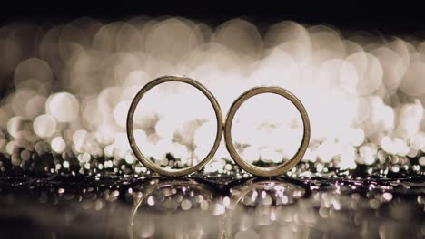 anillos de bodas en la superficie del agua oscura brillando con la luz. macro de primer plano