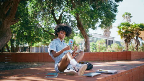 trendy girl making selfie on smartphone sitting ground under street trees.