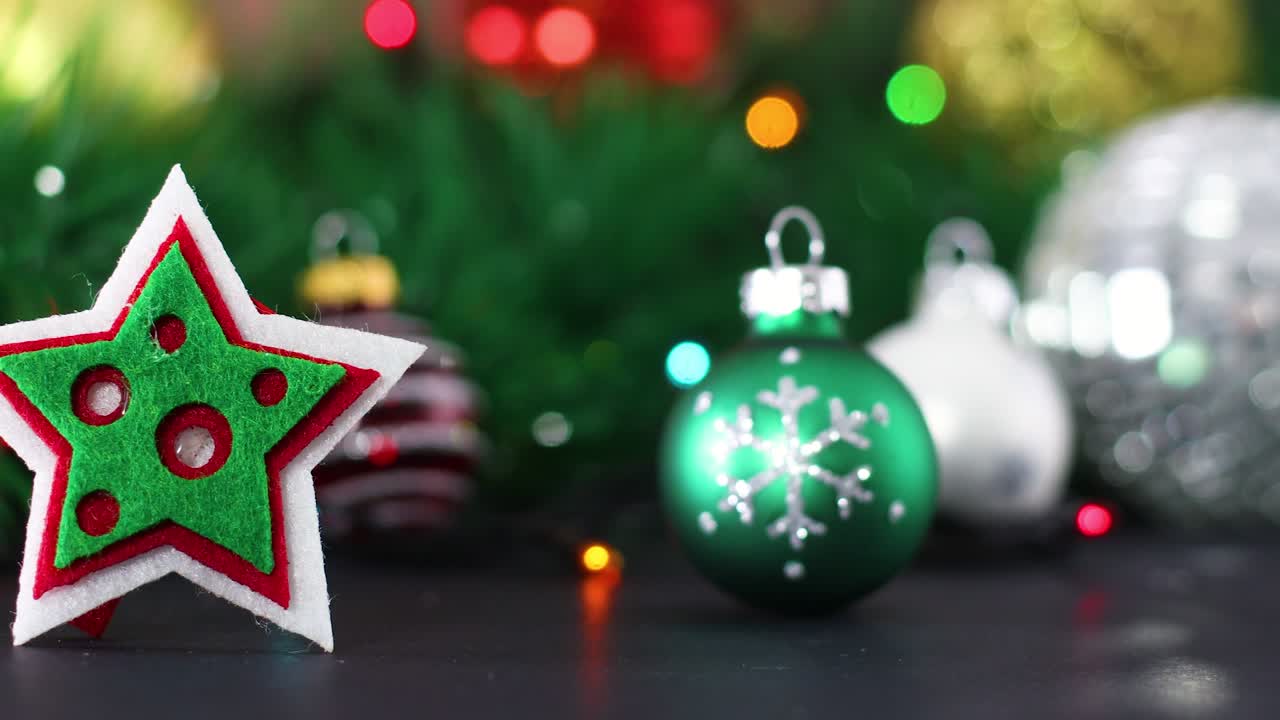 adornos de navidad y estrella de navidad con luces parpadeantes detrás