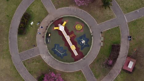 toma aérea de arriba hacia abajo del patio de recreo redondo en buenos aires cerca del área del parque, toma circular