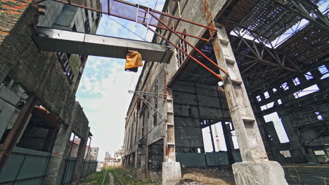 the ruins of an old factory. the abandoned building was covered with grass and trees. holes and cracked in the walls and ceiling. reinforced concrete and brick construction collapse.
