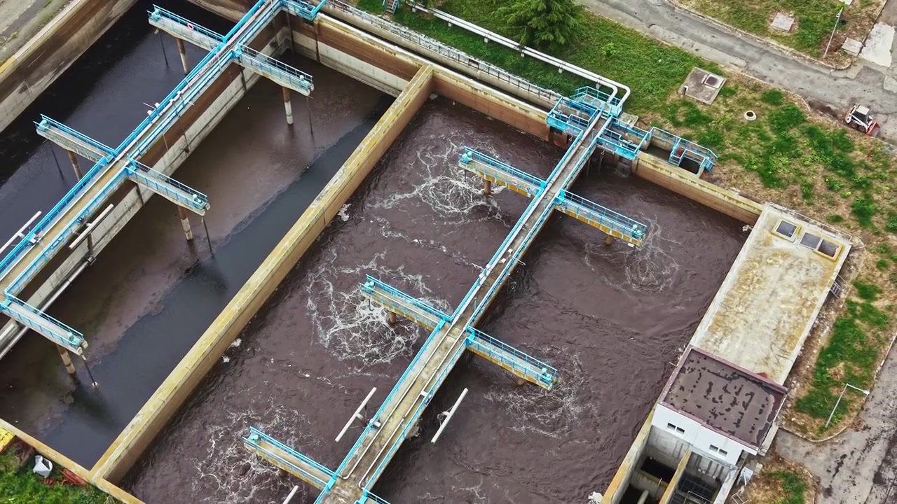 Water treatment facility operates in a suburban area during daytime with flowing water being processed for purification