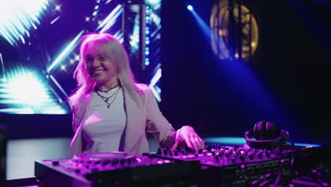 a female dj performing on stage at a nightclub.