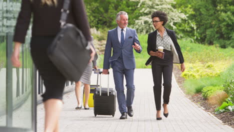 group of business delegates with luggage arriving at conference hotel