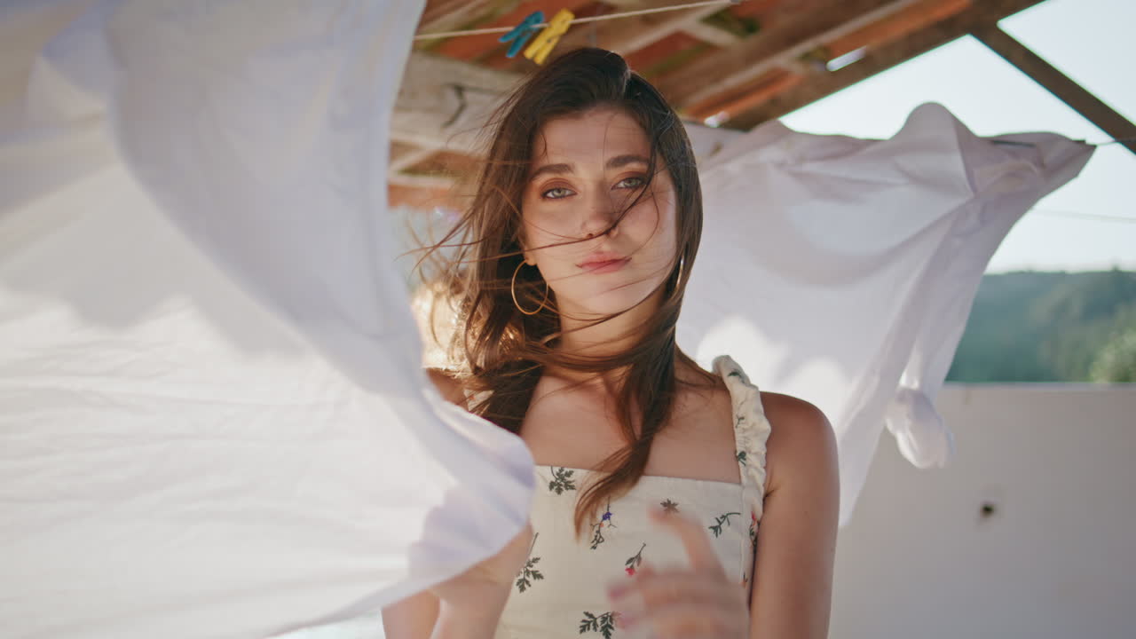 mujer de la lavandería mirando la cámara en el retrato de la terraza ventosa. mujer seductora posando
