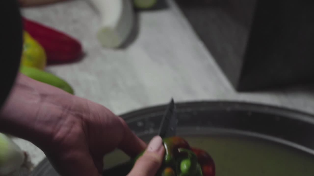 여성의 손을 씻고 껍질을 벗기고 야채를 야채 스튜로 자릅니다.