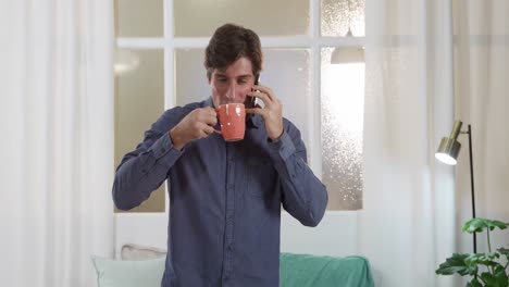 Caucasian-man-using-his-phone-and-drinking-coffee