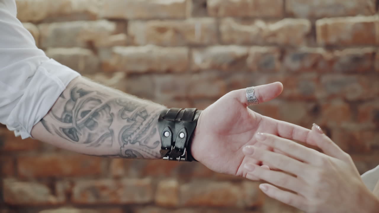 Female hand in male. Close up of romantic couple holding hands at restaurant