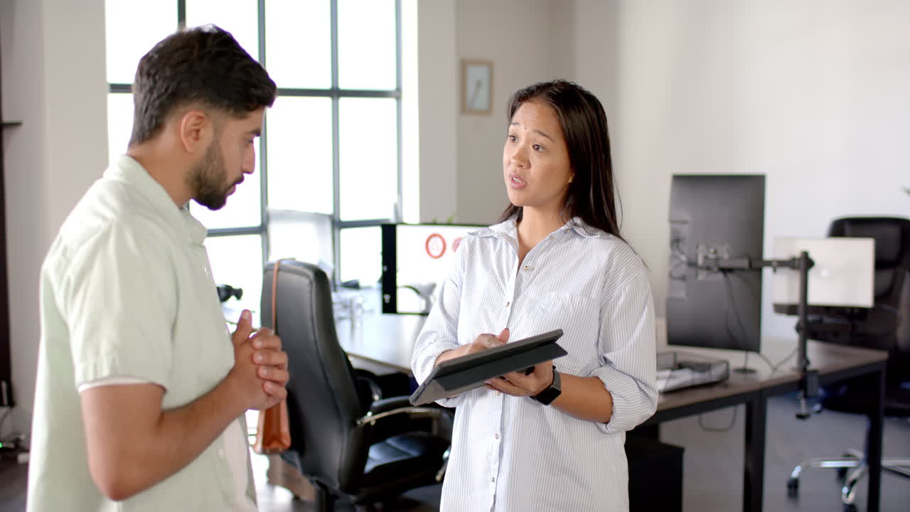 Discussing project details, colleagues in modern office with tablet and computer screens