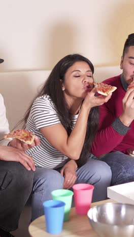 friends eating pizza and relaxing at home