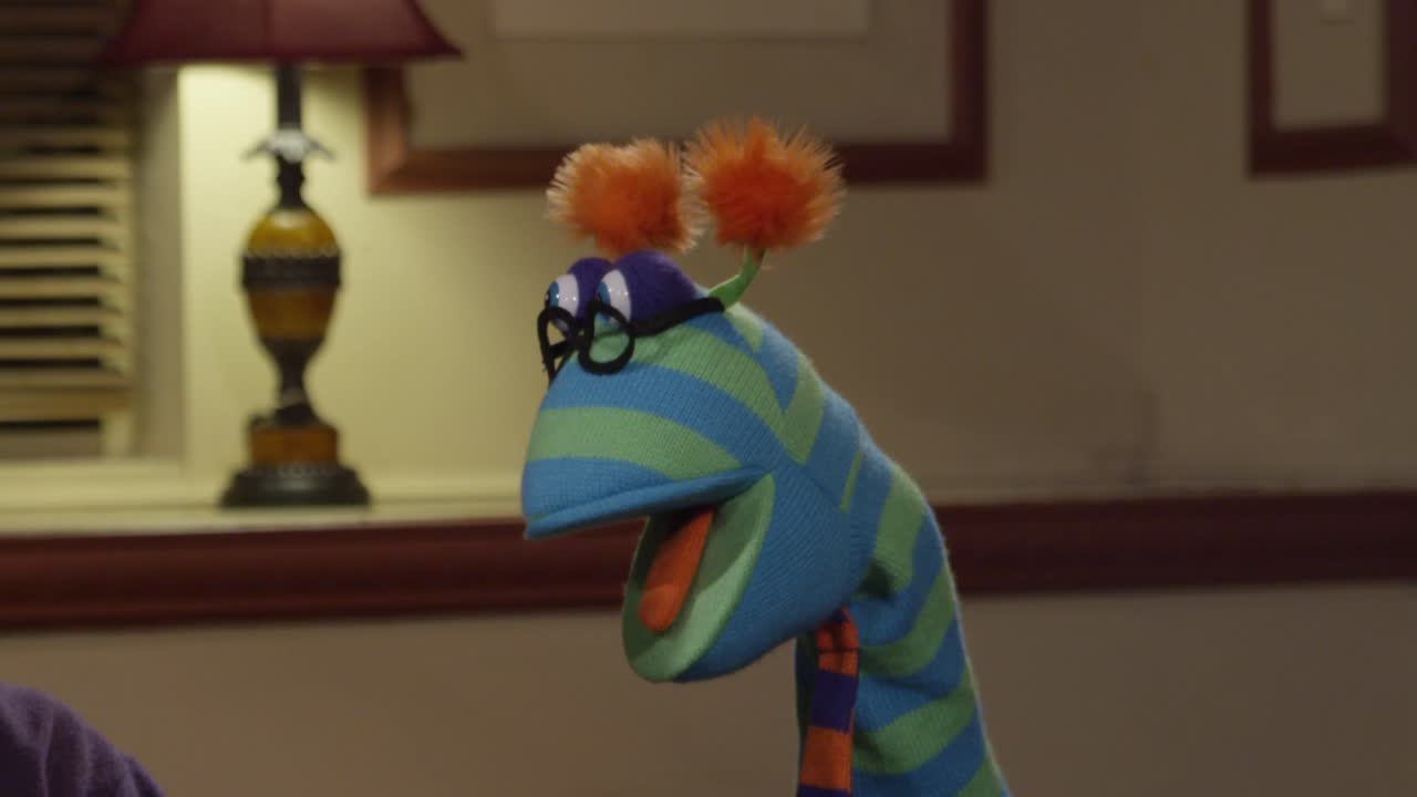 Funny and Goofy Puppet Wearing Glasses and a Tie on a Movie Set Being Over Dramatic
