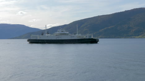 a ferry travels through a fjord on a sunny summer day in norway, slow motion