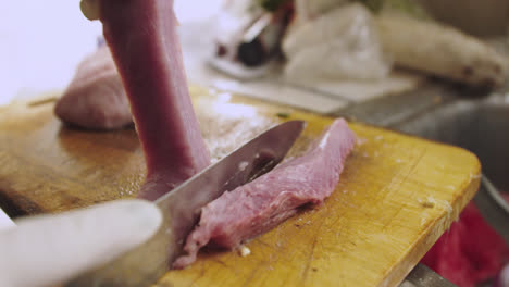 cortar pescado crudo en trozos para preparar ceviche