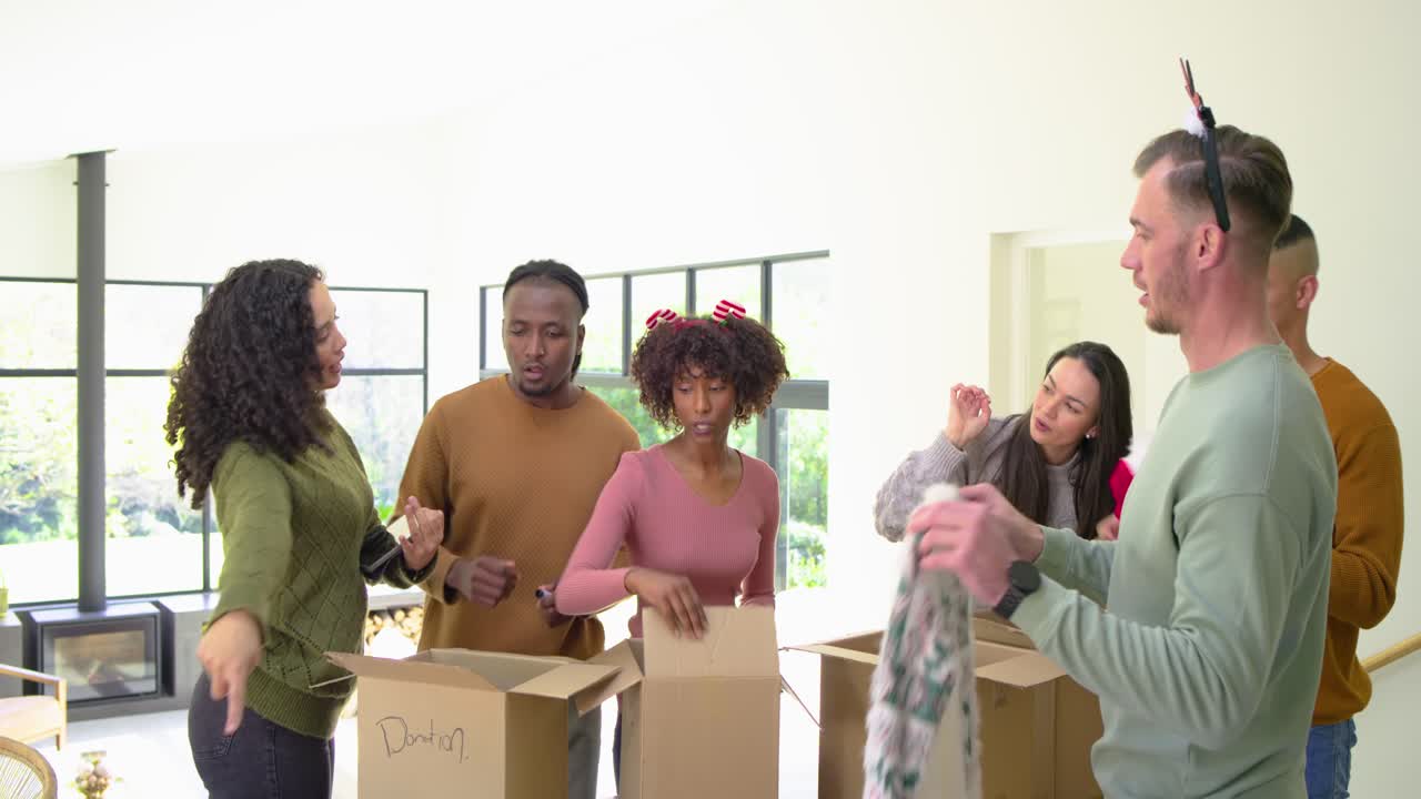 Diverse volunteers greeting at home, sorting into boxes, tossing ball, packing jars for charity