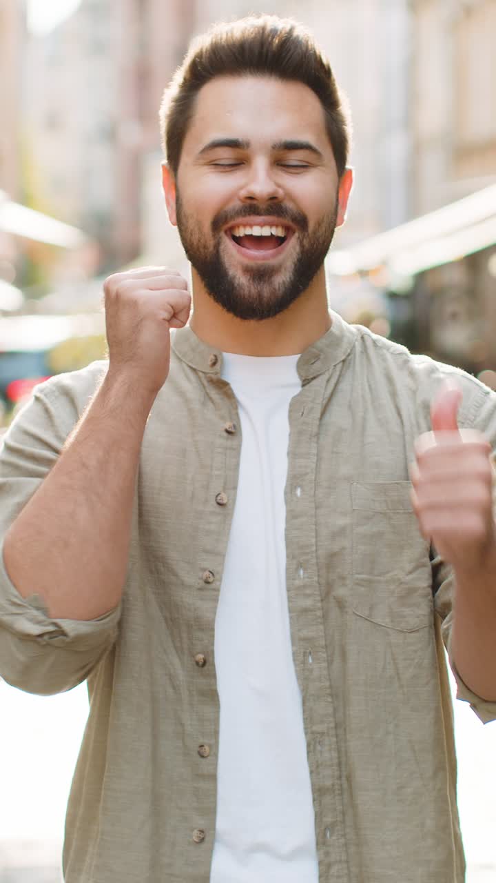 Hombre feliz mostrando pulgares hacia arriba como señal positiva algo bueno retroalimentación positiva en la calle de la ciudad