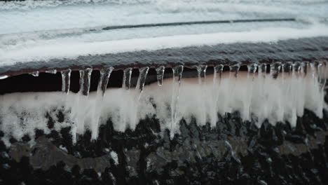 close-up of frosted car glass covered in snow and icicles during winter, capturing frozen ice details, textured surface, and cold seasonal atmosphere