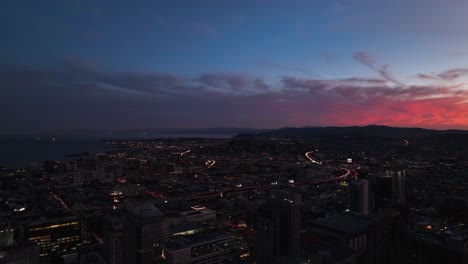 scenic aerial above san francisco cityscape at dusk with pink clouds on horizon