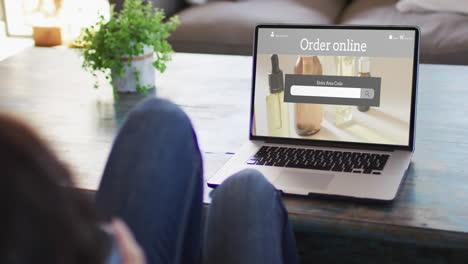 woman at table using laptop, online shopping for beauty products, slow motion