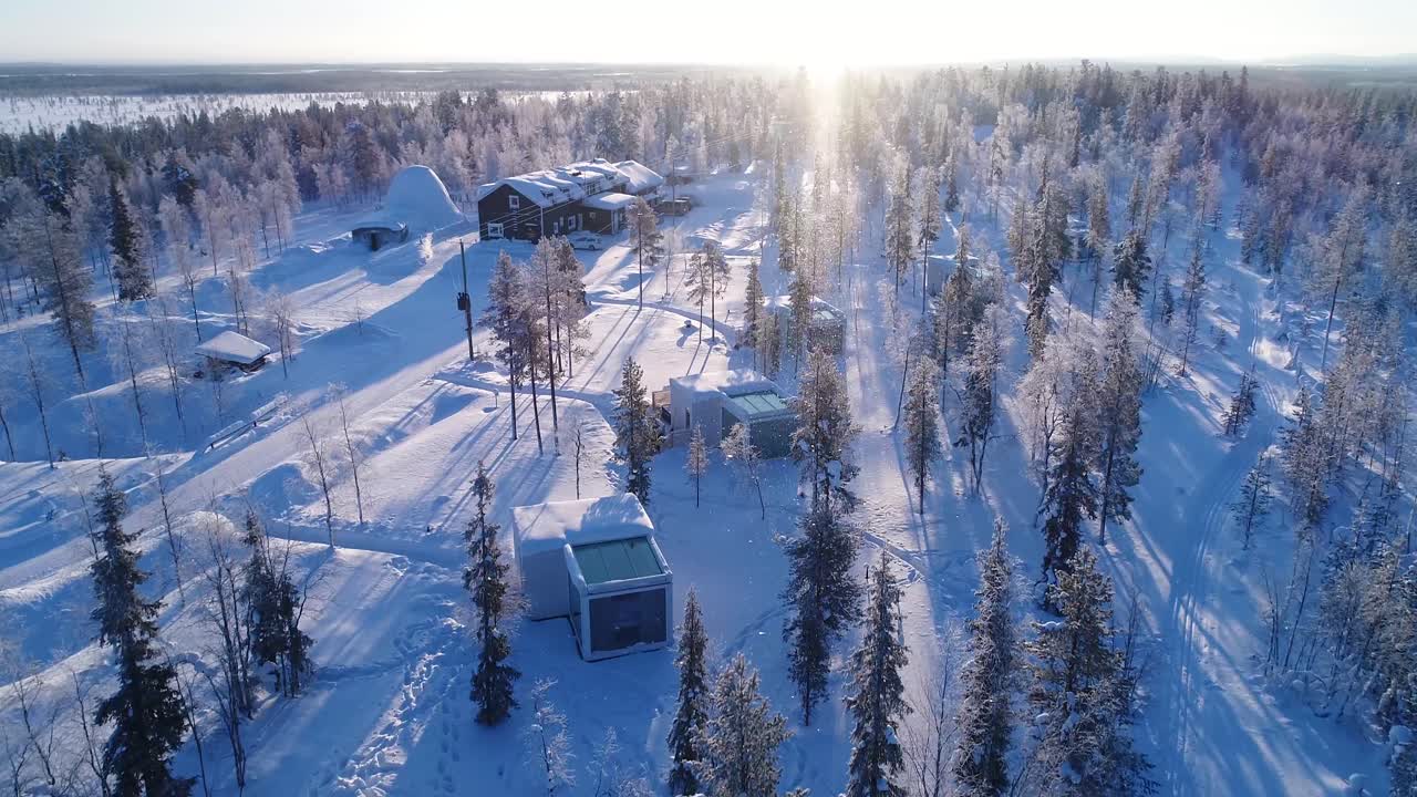 Et luftfoto viser trær og overnattingssteder på den snødekte Nordlys-ranchen i Kongas, Finland