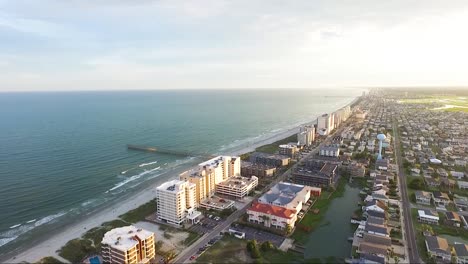 drone flying over an island at sunset towards pier