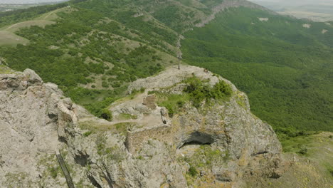 a forested scenery and an old cross on top of the azeula fortress ruins