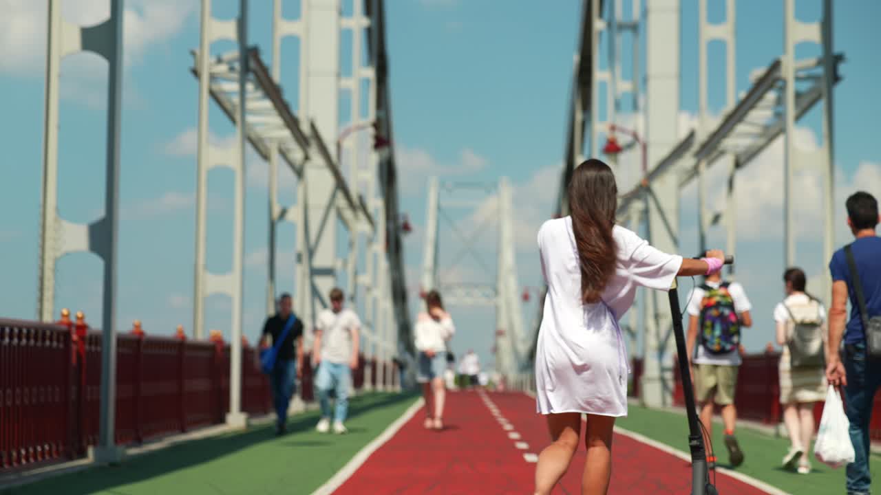 도시 다리 에서 스쿠터 를 타고 고 있는 사람 들