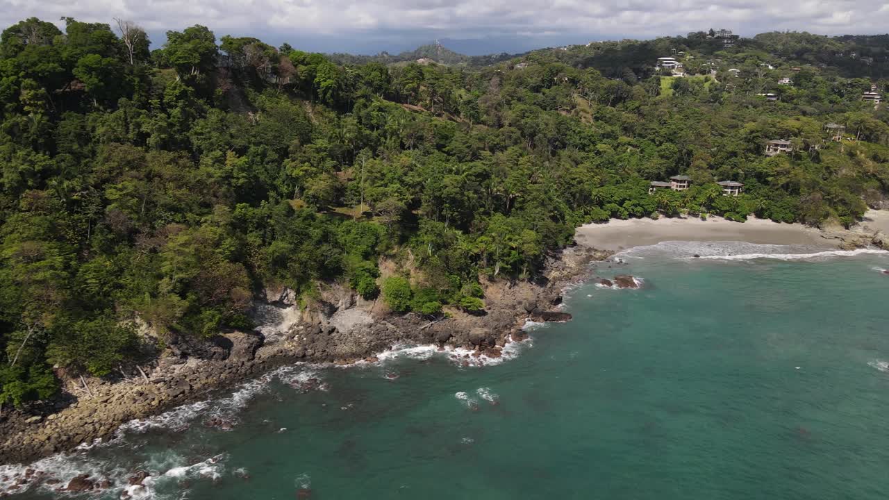drone disparado volando sobre el agua turquesa hacia la costa, manuel antonio, costa rica